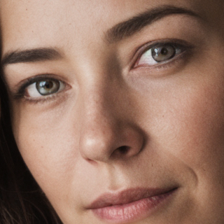 Matching 320-pixel crop from the AI enlargement showing reconstructed facial texture