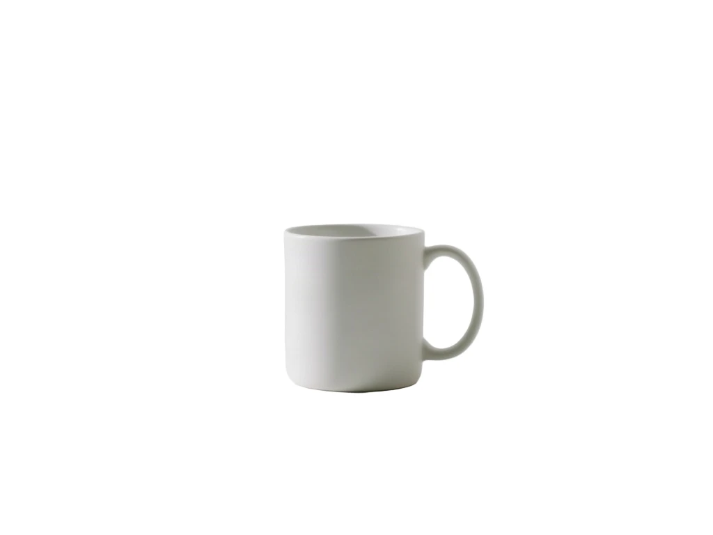 Matte white ceramic mug on a white table against a white wall cut out and placed on pure white
